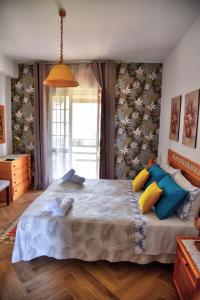 a bedroom with a large bed with colorful pillows at Simo Amour in Lercara Friddi