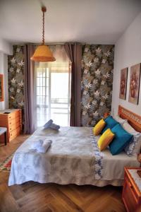 um quarto com uma cama grande e almofadas coloridas em Simo Amour em Lercara Friddi