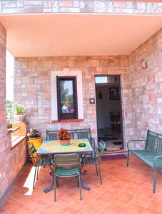 un patio con tavolo e sedie su un muro di mattoni di Simo Amour a Lercara Friddi
