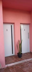 dos puertas blancas en una habitación con una maceta en Catamarca Apart en Ramallo