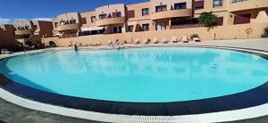 una grande piscina di fronte a un edificio di Bahia Sol Dream -Caleta de Fuste- a Caleta De Fuste