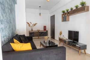 ein Wohnzimmer mit einem Sofa und einem TV in der Unterkunft The House Project in Athen