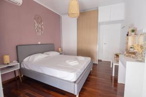 Schlafzimmer mit einem großen weißen Bett und Holzböden in der Unterkunft The House Project in Athen