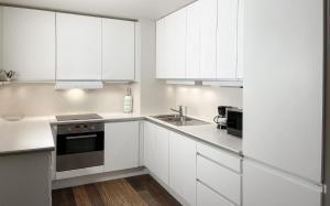 a white kitchen with white cabinets and a sink at Pallace House in Oslo