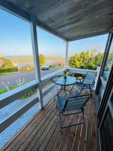 a porch with two chairs and a table on it at Auckland Beachview Homestay with free Netflix, Parking in Auckland