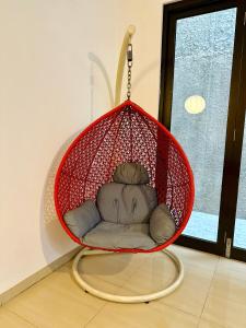 a hanging basket chair in a room with a window at 4-Bedroom Home in South Jakarta Nuansa Swadarma Residence by Le Ciel Hospitality in Jakarta