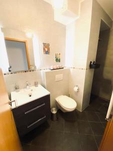 uma casa de banho com um WC branco e um lavatório. em Large Studio in Center with Terrace-Cosy em Luxemburgo