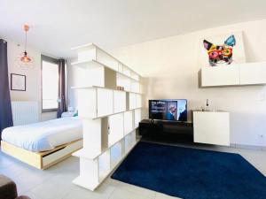 um quarto branco com uma cama e uma televisão em Large Studio in Center with Terrace-Cosy em Luxemburgo