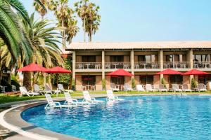 un complejo con piscina con sillas y sombrillas en Wyndham Costa del Sol Trujillo, en Trujillo