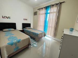 een kamer met 2 bedden in een kamer bij Toque_a_campainha Apto Blue completo in Cabo Frio