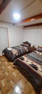 2 camas en una habitación con suelo de madera en Cabañas San Alfonso, en Chile Chico