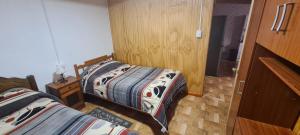 um quarto com 2 camas e uma porta de madeira em Cabañas San Alfonso em Chile Chico