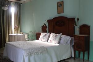 1 dormitorio con 1 cama con sábanas y almohadas blancas en Ca Les Senyoretes, en Otos