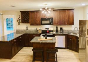 cocina con armarios de madera y encimera en Pensa-Cozy Downtown bungalow, w/ backyard oasis! en Pensacola