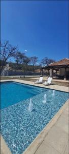a swimming pool with two white lounge chairs in it at Casa las flores in San Pedro Las Huertas
