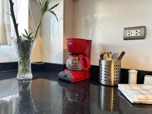 a red blender sitting on a counter with a vase at Zona Exclusiva Céntrico 7 pers. Cochera in Arequipa
