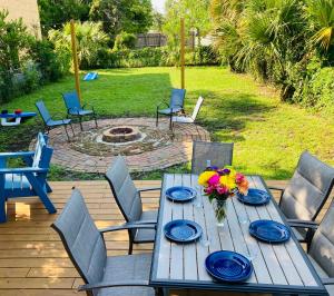 una mesa de madera con platos azules y flores en el patio en Pensa-Cozy Downtown bungalow, w/ backyard oasis! en Pensacola
