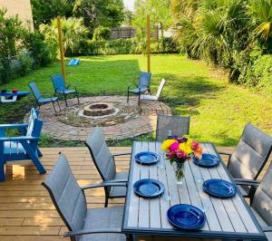 a wooden table with blue plates and flowers on a patio at Pensa-Cozy Downtown bungalow, w/ backyard oasis! in Pensacola