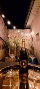 dos copas de vino y una botella de cerveza en una mesa en L'antre d'Eros, en Romans-sur-Isère