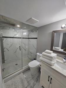 a bathroom with a shower and a toilet and a sink at Basement Apartment in Luxury Beach House in Toronto