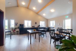 DalsSel farm Guesthouse في Hólmabæir: غرفة طعام مع طاولات وكراسي في غرفة