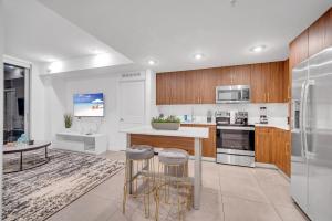 a kitchen with a counter and two bar stools at Exclusive Condo in Downtown Miami With Pool Views and Free Parking in Miami