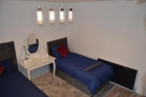 - une chambre avec un lit et un miroir dans l'établissement Luxury Home Close to Leeds City Centre, à Leeds