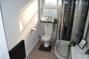 uma casa de banho com um WC e um chuveiro em Luxury Home Close to Leeds City Centre em Leeds