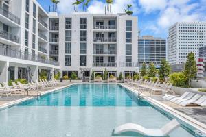 a swimming pool with chairs and a building at Exclusive Condo in Downtown Miami With Pool Views and Free Parking in Miami