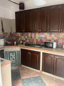 a kitchen with brown cabinets and a microwave on the wall at Coremi in Naples +12 photos