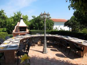a long wooden table with chairs and a street light at Casa da Horta, Vale carro Olhos de Agua in Albufeira