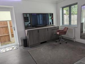 a living room with a television and a chair at Claresholm in Barnet