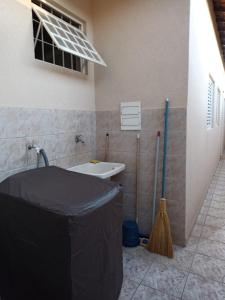 a bathroom with a tub and a sink and broom at Quarto Due na Sakura House in Indaiatuba