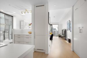 a kitchen with white counters and a long hallway at Spacious modern 2BR apartment at Central OSLO BARCODE in Oslo