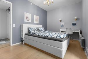 um quarto com uma cama com almofadas azuis e brancas em Luxurious 2BR apartment at Central OSLO BARCODE em Oslo