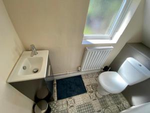 łazienka z umywalką, toaletą i oknem w obiekcie Wollaton Park Beeston house close to University w Nottingham