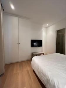 una camera bianca con letto e TV di Luxury Appartment, Champs Elysées, Neuf ! a Parigi