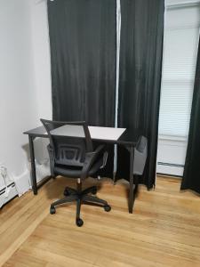 a desk with a chair in front of a black curtain at Cozy, spacious and peaceful in Providence