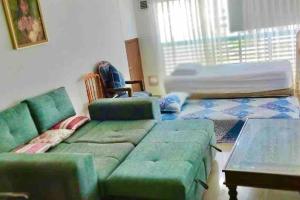 a living room with a green couch and a bed at Sea View 603B in San Andrés