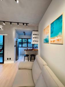 uma sala de estar com um sofá e uma cozinha em PALMAS EXPERIENCE - Apartamento Girassol em Palmas