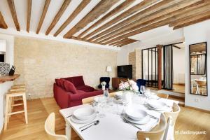 een woonkamer met een tafel en een rode bank bij Amazing Apartment 2BR6P - St Lazare South Pigalle in Parijs