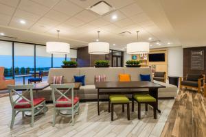 vestíbulo con sofá, mesa y sillas en Home2 Suites by Hilton Buffalo Airport/ Galleria Mall en Cheektowaga