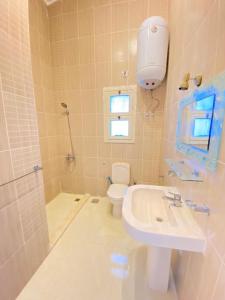 a bathroom with a toilet and a sink and a shower at فيلا للإيجار مارينا 7 الساحل الشمالي in El Alamein