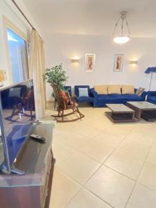 a living room with a blue couch and a table at فيلا للإيجار مارينا 7 الساحل الشمالي in El Alamein