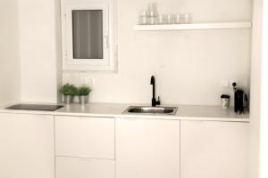 a white kitchen with a sink and a mirror at Citybreak Apartments 302 in Athens