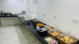 una línea de buffet con muchos tipos diferentes de comida en Hotel Tenda Diadema, en Diadema