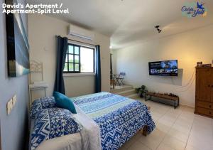 a bedroom with a bed and a tv in it at Casa de Yoli in Cozumel