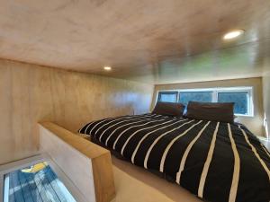 a bedroom in a tiny house with a bed at Tui Nature Retreat in Hotwater Beach