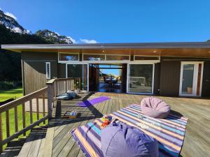 a house with a mattress on a deck at Tui Nature Retreat in Hotwater Beach