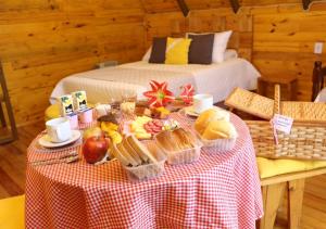a table with a plate of food on it with two beds at Estalagem Refúgio do Capão in Cambará